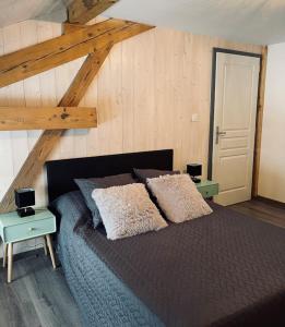 - une chambre avec un lit et 2 oreillers dans l'établissement Le Gîte de mon grand père, à La Bresse