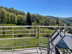 un banc bleu sur une terrasse avec vue sur la montagne dans l'établissement Le Gîte de mon grand père, à La Bresse
