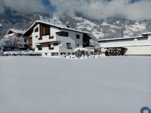 uma casa na neve em frente a uma montanha em Landhaus Barbara em Hippach