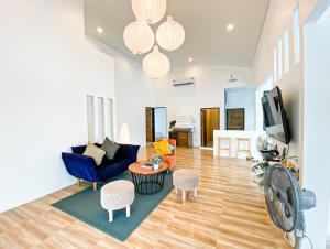 a living room with a blue couch and a table at Ban Rub Lom Pool Villa 3 difference villas in Rayong