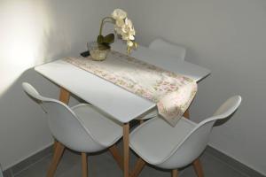 a white table with two chairs and a table cloth on it at lividio apartment in Lefkada