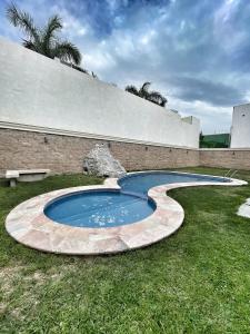 uma pequena piscina na relva ao lado de uma parede em Room in Guest room - 22 Suite for two people em Torreón