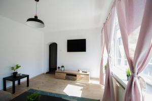 a living room with a large window with pink curtains at Bright apartment near Cismigiu and Old Town in Bucharest
