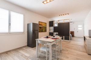een keuken met een witte tafel en een koelkast bij Home situated not far beach in Torre di Fine