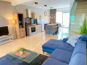 a living room with a blue couch and a kitchen at Villetta Mia in Njivice