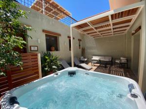 a hot tub in a yard with a patio at Andros 4 All Seasons Villas & Suites in Andros