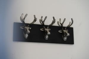 dwie głowy jeleni z porożami na czarnej półce w obiekcie Risca Retreat w mieście Risca