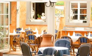 an outdoor patio with tables and chairs and windows at Dino's Trinacria in Friesenheim