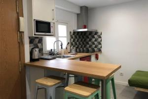a kitchen with a sink and a counter with stools at M3 Terrace. Cool apartment 15 min center by metro in Esplugues de Llobregat