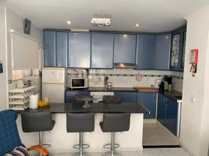a kitchen with blue cabinets and a black counter top at Apartamento Limões in Carvoeiro +25 photos