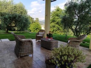 カプリーノ・ヴェロネーゼにあるCarmen de Nella Eco Lodge 4*のパティオ(籐の椅子、テーブル付)
