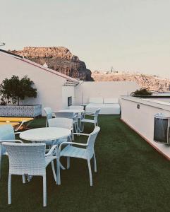 a group of tables and chairs on a patio at Apartamentos Tapahuga in Playa de Santiago