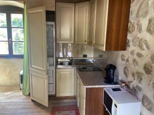 a kitchen with white cabinets and a microwave at La Columbera in Trento