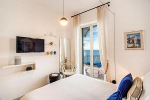 une chambre avec un lit et une vue sur l'océan dans l'établissement VILLAPOSITANO Tre Archi, à Positano
