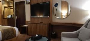 a hotel room with a bed and a mirror at Golden Tower Hotel AlKhobar Corniche in Al Khobar