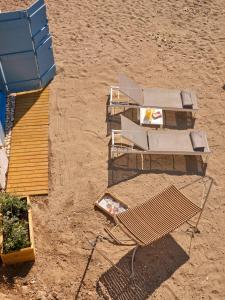 an overhead view of a beach with a bench and tables at The Elephant Beach House in Kimolos