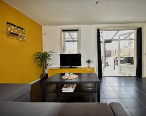 a living room with a couch and a tv at 't zeeuwse achteruusje in Sint Annaland