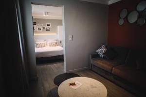 a room with a bed and a couch and a mirror at Best Western Plus La Corniche in Toulon