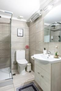 a bathroom with a toilet and a shower and a sink at Place to be Athens apartment in Athens