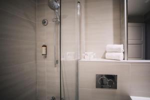 a bathroom with a shower with towels on a counter at Best Western Plus La Corniche in Toulon
