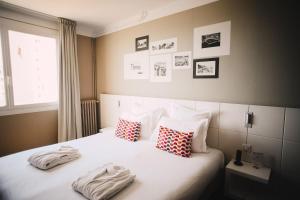 a bedroom with a bed with pillows and pictures on the wall at Best Western Plus La Corniche in Toulon