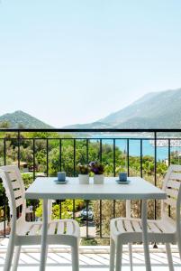 een witte tafel en stoelen op een balkon met uitzicht bij La Moda Aparts in Kas