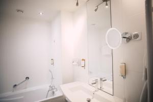 a white bathroom with a sink and a mirror at Best Western Plus La Corniche in Toulon