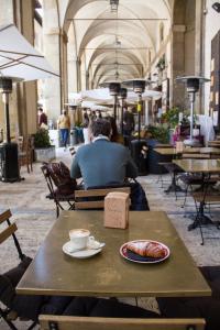 Ein Mann, der mit einer Tasse Kaffee an einem Tisch sitzt. in der Unterkunft Appartamento Porta Crucifera in Arezzo