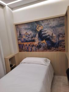 ein Schlafzimmer mit einem Gemälde an der Wand neben einem Bett in der Unterkunft Hotel Mairena in Mairena del Alcor