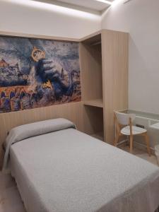 ein Schlafzimmer mit einem Bett und einem Wandgemälde in der Unterkunft Hotel Mairena in Mairena del Alcor