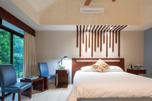 A bed or beds in a room at Pumilio Mountain & Ocean Hotel