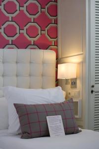 a bedroom with a bed with a red wall at Hotel New York by WestCord in Rotterdam