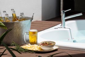 una mesa con un tazón de comida y un vaso de cerveza en Pumilio Mountain & Ocean Hotel, en Jacó