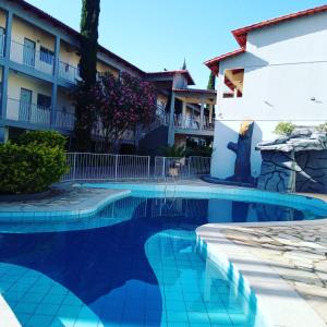 a swimming pool in front of a building at Pousada 4 Estações in Caldas Novas