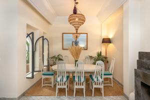 uma sala de jantar com uma mesa branca e cadeiras em Riad D'ari em Marrakech
