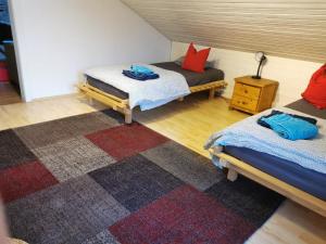 een kamer met 2 bedden en een tapijt bij Monteurzimmer am Teisenberg in Neukirchen am Teisenberg