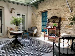 ein Wohnzimmer mit einem Tisch und einer Steinmauer in der Unterkunft Casa Portus Gaditanus s XVIII Patio Andaluz in El Puerto de Santa María