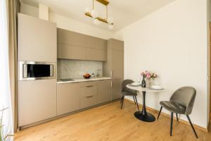 a kitchen with two chairs and a table in a room at West In Apartment in Liepāja