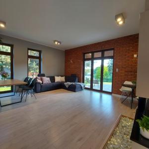a living room with a blue couch and a brick wall at Slow life nad jeziorem in Łukta