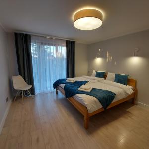 a bedroom with a large bed and a large window at Slow life nad jeziorem in Łukta