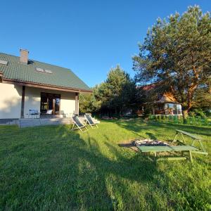 a picnic table in the grass in front of a house at Slow life nad jeziorem in Łukta