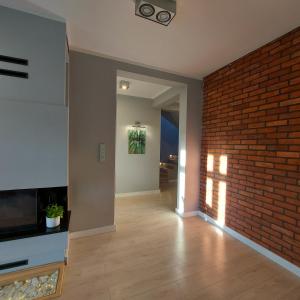 a living room with a brick wall and a fireplace at Slow life nad jeziorem in Łukta
