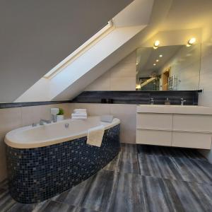 a bathroom with a sink and a bath tub at Slow life nad jeziorem in Łukta +27 photos