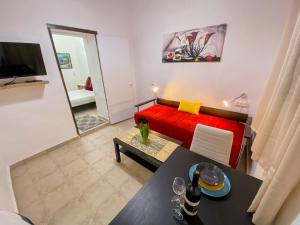 a living room with a red couch and a table at Old Town Guest House in Beer Sheva