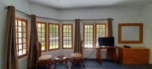 a room with windows and a desk and a television at Hotel Reego in Skardu