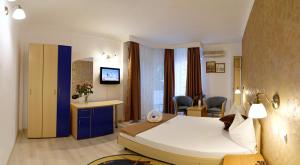 a hotel room with a bed and a desk and chairs at Hotel Albatros in Mamaia