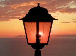 una luz de la calle con la puesta de sol en el fondo en ZIO DOMENICO Al Vicolo en Castellabate