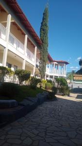 a large white building with a tree in front of it at Pousada 4 Estações in Caldas Novas