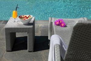 - une table et des chaises avec un bol de fruits et une boisson dans l'établissement Xerolithia, à Kamarai