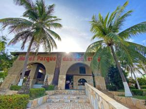 een gebouw met twee palmbomen ervoor bij Hotel Parque das Fontes in Beberibe
